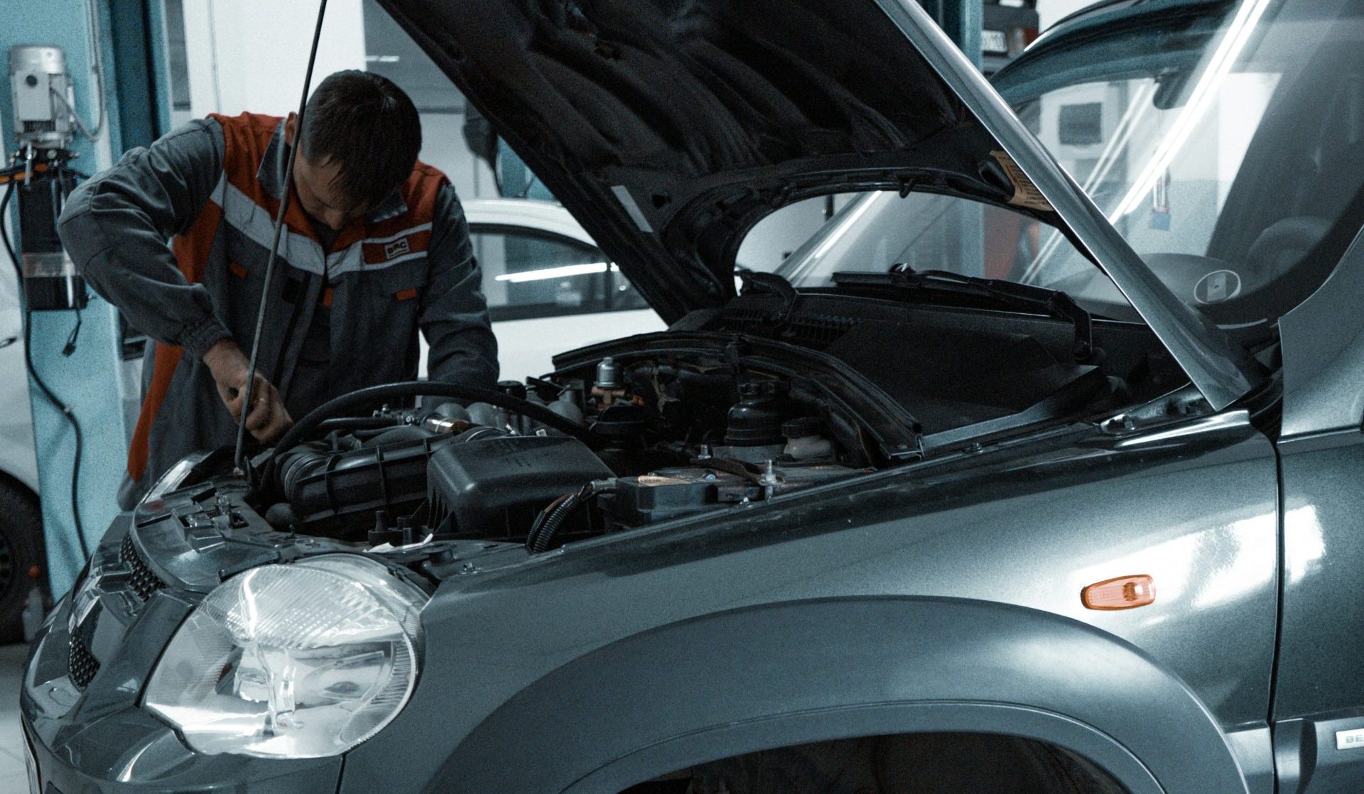 man in black jacket standing beside black car