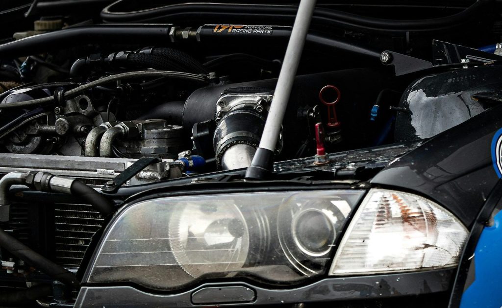 Car with hood open showing engine and headlights